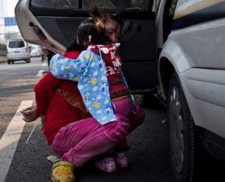 冲突发生后，女小贩的孩子惊恐地抱着被反绑的妈妈.jpg